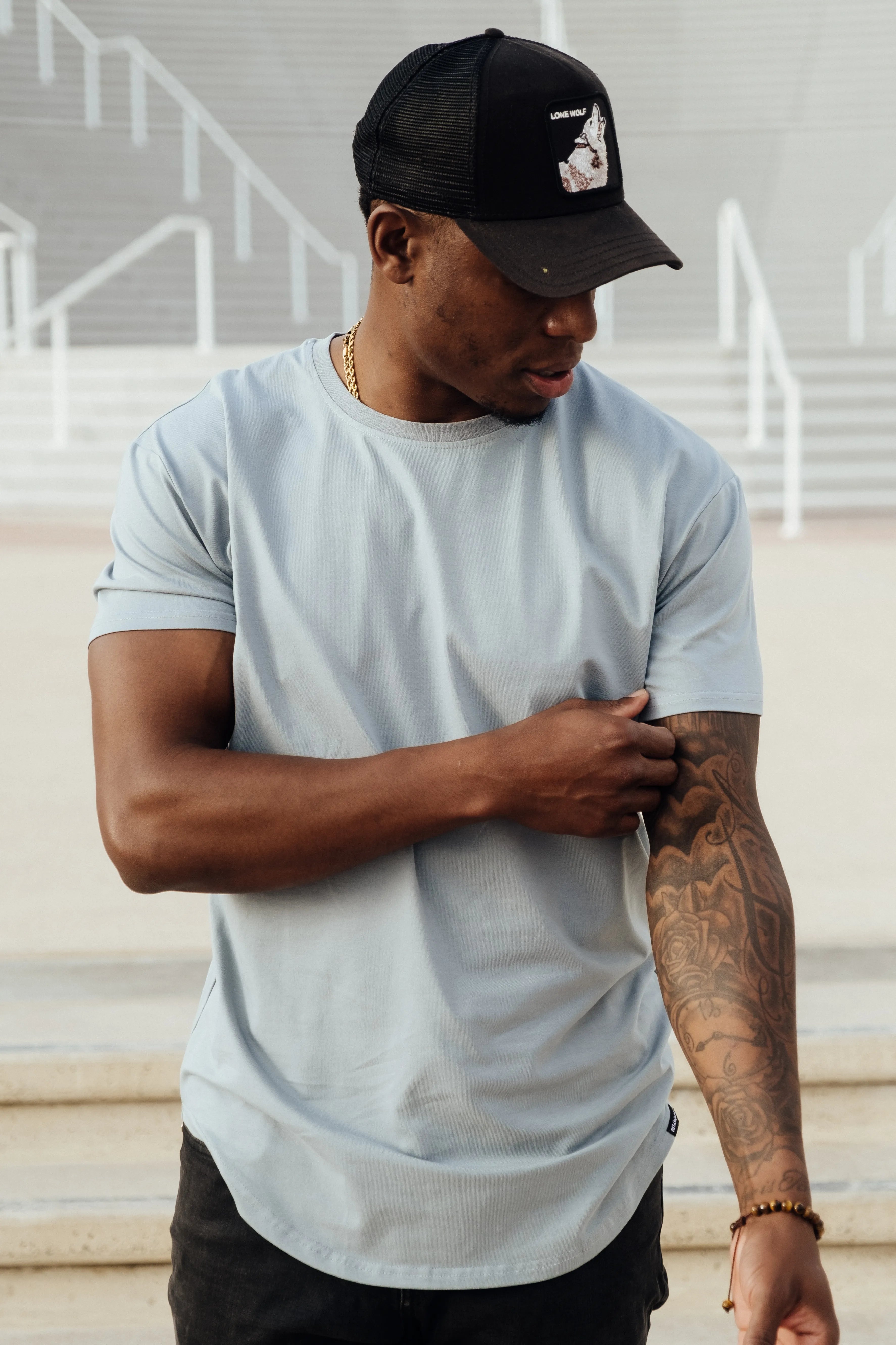 Drop-cut tee worn on stairs